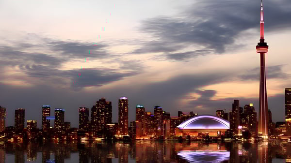 Nächtliche Stadtansicht mit gewölbtem Gebäude im Vordergrund auf dem Gelände des Albert Campbell Collegiate Institute.