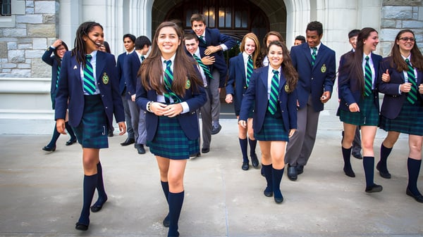 Schülerinnen und Schüler des Albert College gehen vor einem steinernen Gebäude auf dem Campus.