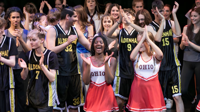 Eine Gruppe junger Menschen feiert gemeinsam auf dem Gelände der Aldenham School.