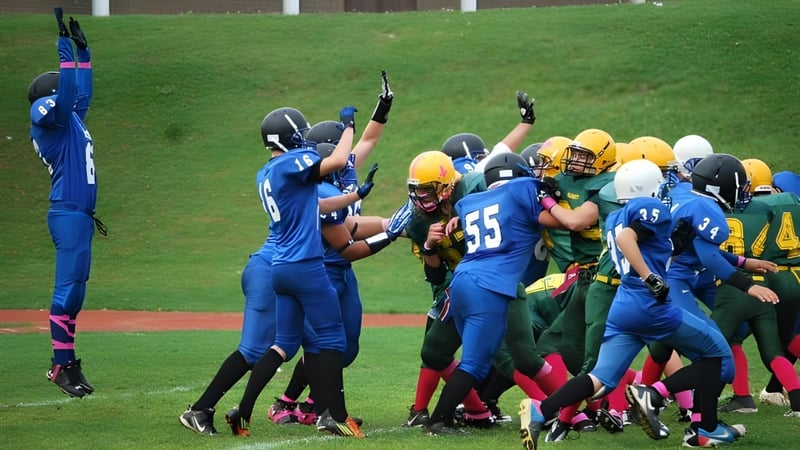 Eine Gruppe von Footballspielern in blauen und gelben Trikots spielt auf dem Spielfeld der Aldershot High School.