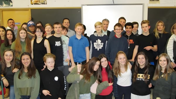 Eine Gruppe von Schülerinnen und Schülern posiert gemeinsam in einem Klassenraum der Aldershot High School.