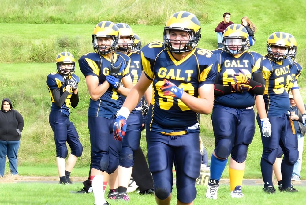 Eine Gruppe junger Fußballspieler steht auf dem Rasenfeld der Alexander Galt Regional High School.