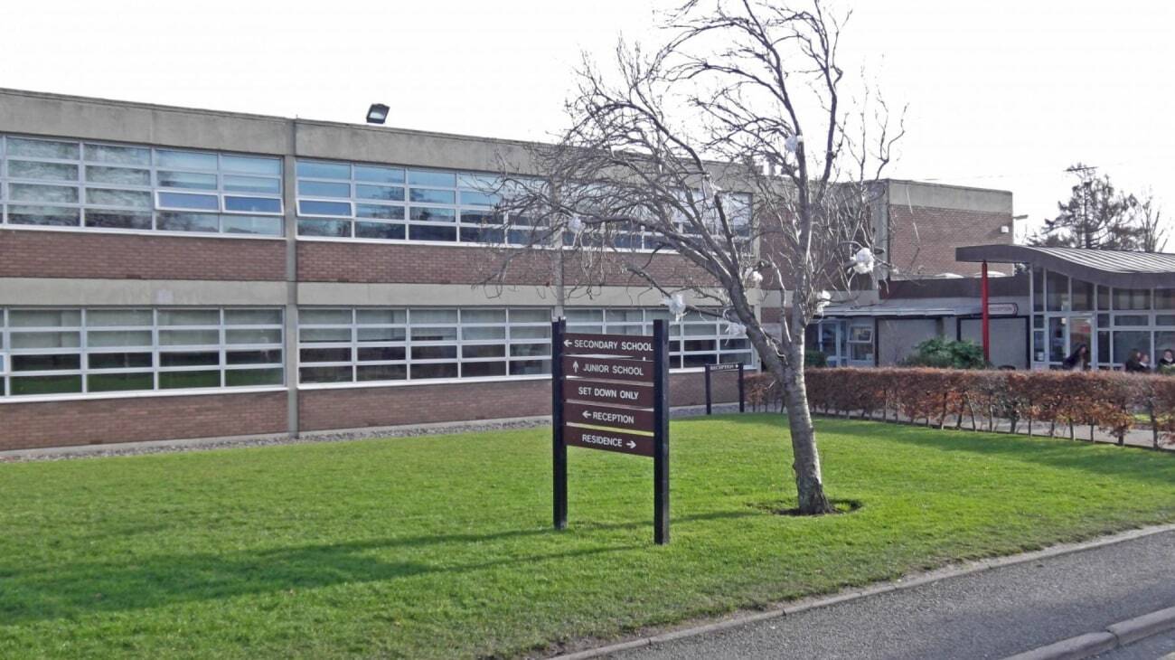 Das moderne mehrstöckige Schulgebäude des Alexandra College mit großen Fenstern und einer Grasfläche im Vordergrund.