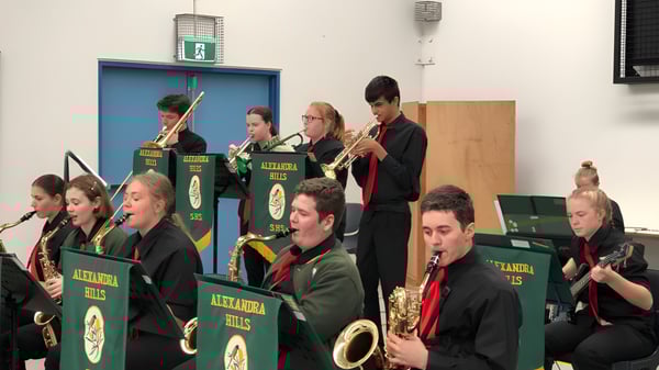 Eine Gruppe von Musikern der Alexandra Hills State High School tritt in einheitlichen Uniformen auf der Bühne auf.