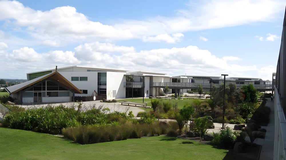 Das Alfriston College zeigt ein modernes Wohngebäude mit gepflegter Außenanlage und bewölktem Himmel.