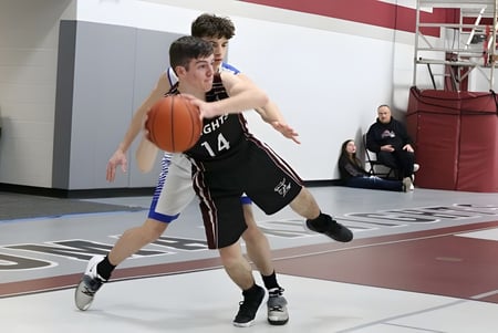 Zwei Schülerinnen und Schüler spielen Basketball auf dem Spielfeld der Algoma Christian High School.