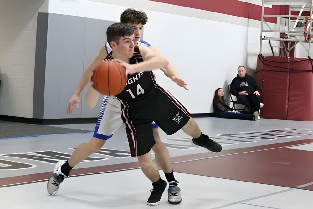 Zwei Schülerinnen und Schüler spielen Basketball auf dem Spielfeld der Algoma Christian High School.