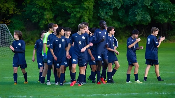 Eine Gruppe junger Fußballspielerinnen und Fußballspieler steht auf dem Sportplatz der Allendale Columbia School im blauen Trikot.
