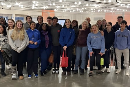 Eine Gruppe Schülerinnen und Schüler steht in einem hellen Innenraum auf dem Campus der Allendale Columbia School.