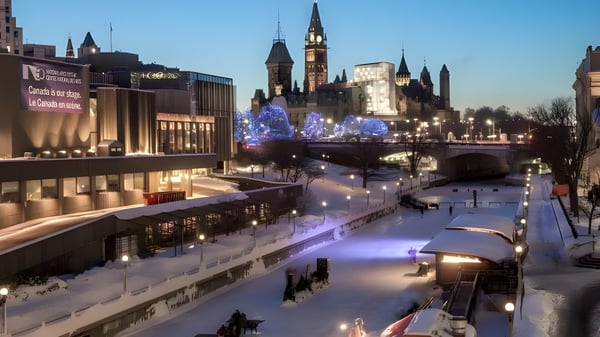 Winterliche Szene mit beleuchtetem Kanal und Kirchturm im Hintergrund nahe der École secondaire publique L'Alternative.