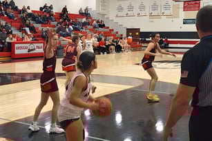 Schüler der American Falls High School spielen ein Basketballspiel auf dem Schulhof mit Zuschauern auf den Rängen.