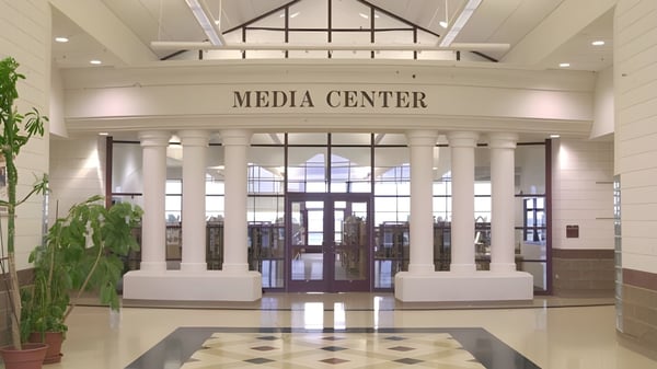 Das Mediacenters der American Falls High School zeigt einen großzügigen Eingangsbereich mit hohen Decken und Säulen.