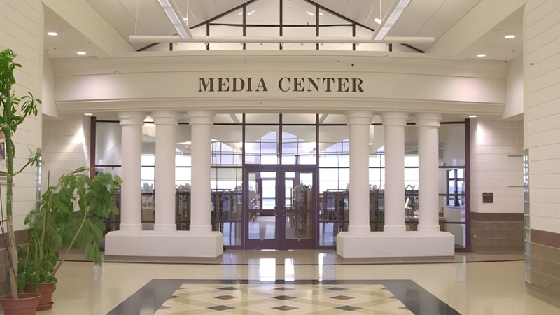 Das Mediacenters der American Falls High School zeigt einen großzügigen Eingangsbereich mit hohen Decken und Säulen.