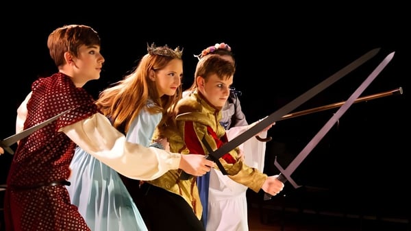 Schüler der American Heritage Academy tragen mittelalterliche Kostüme und führen ein Theaterstück mit Schwertern auf.