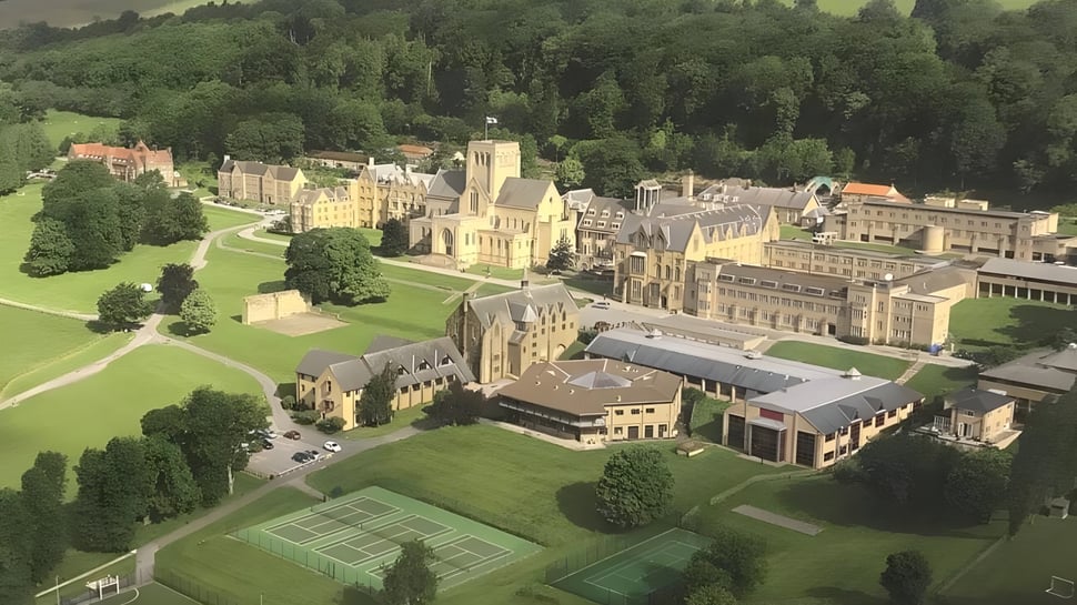 Das Ampleforth College zeigt ein mittelalterliches Schloss mit gepflegten Rasenflächen und Tennisplätzen in einer grünen Landschaft.