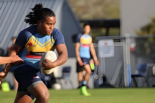 Eine Schülerin läuft auf dem Sportfeld des Aorere College, während weitere Personen im Hintergrund zu sehen sind.