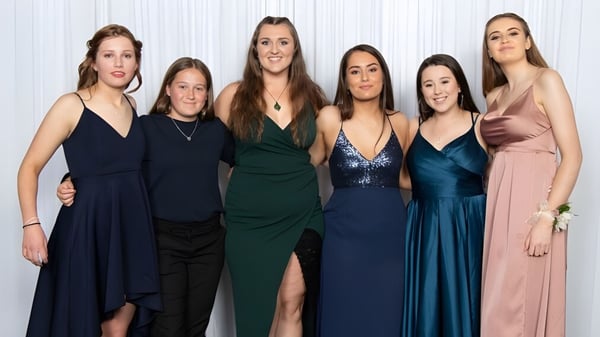 Eine Gruppe von sechs Schülerinnen in unterschiedlichen Abendroben auf dem Campus des Aotea College vor weißem Hintergrund.