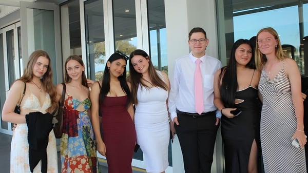 Eine Gruppe von Personen steht vor dem Glasgebäude der Applecross Senior High School.