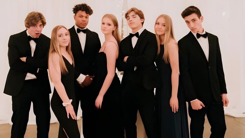 Eine Gruppe formell gekleideter Personen posiert gemeinsam im Gebäude der Arcadia High School.