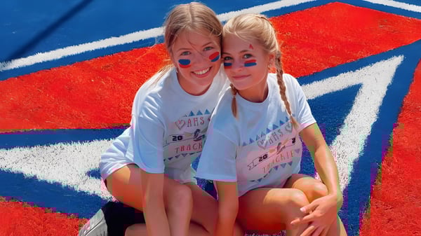 Zwei Schülerinnen der Arcadia High School posieren vor einem rot-weiß-blauen Hintergrund.