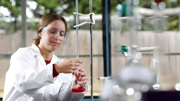 Eine Frau im weißen Laborkittel führt ein Experiment im Labor der Archbishop's School durch.