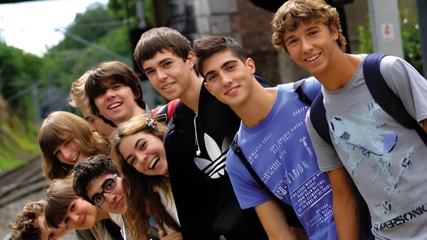 Eine Gruppe von Schülern der Ardscoil Phadraig steht im Freien zusammen und lächelt vor Bäumen und Gebäuden.