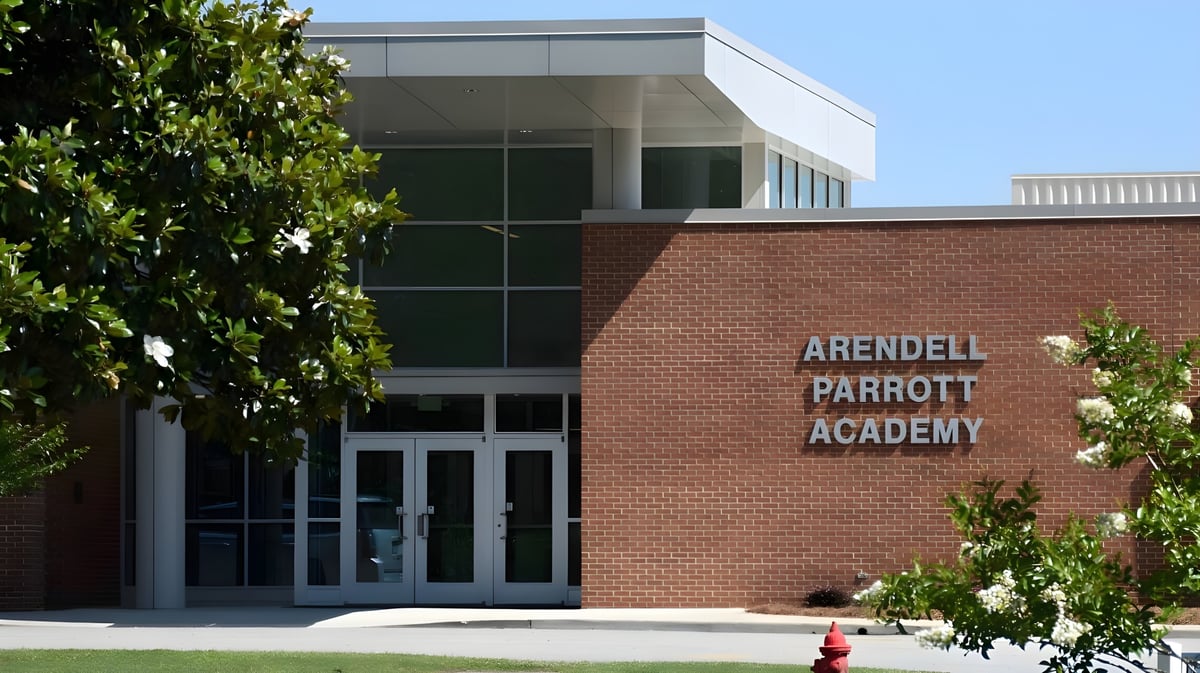 Das moderne Backsteingebäude der Arendell Parrott Academy mit großen Glasfenstern ist zu sehen.