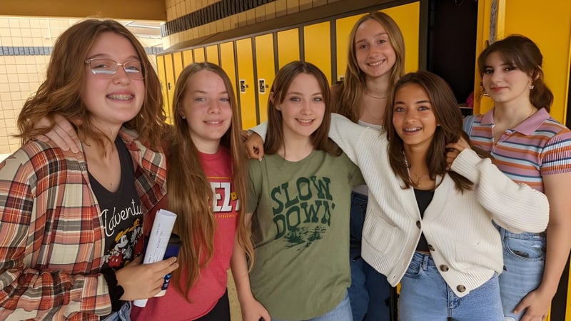 Eine Gruppe junger Schülerinnen steht gemeinsam im Flur der Arizona Lutheran Academy mit Schließfächern im Hintergrund.