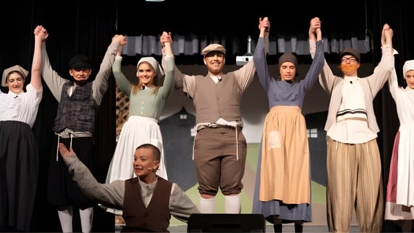 Schüler der Arizona Lutheran Academy führen eine Theateraufführung auf einer Bühne mit dunklem Hintergrund auf.