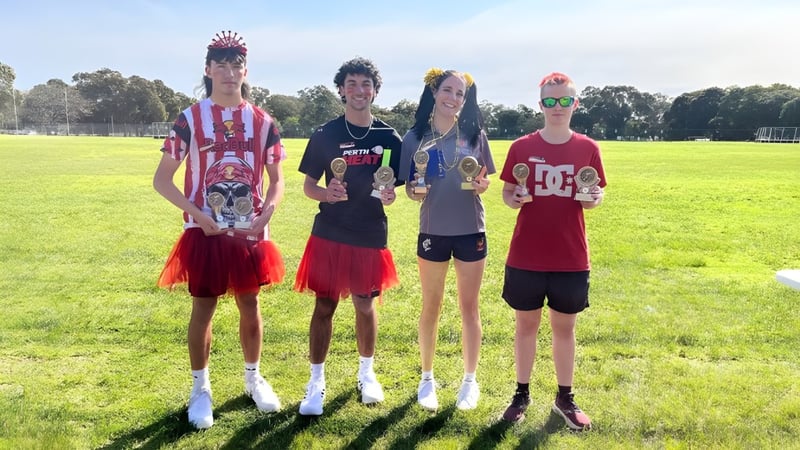 Eine Gruppe von vier Schülerinnen und Schülern steht auf einer Wiese auf dem Gelände der Armadale Senior High School.