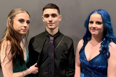 Drei Personen posieren zusammen vor grauem Hintergrund auf einem Teamfoto der Armadale Senior High School.