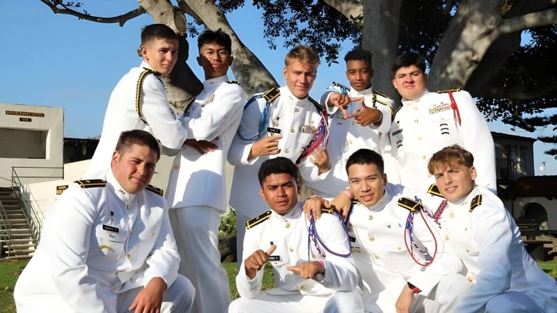 Eine Gruppe von Schülerinnen und Schülern der Army and Navy Academy posiert im Freien vor Bäumen und einem Gebäude.