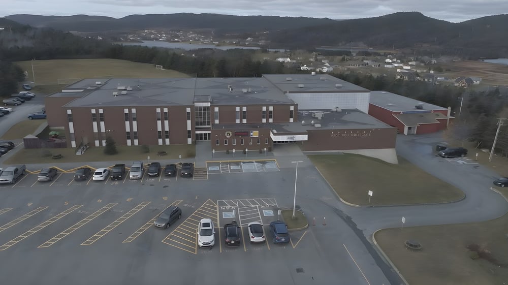 Das große gewerbliche Gebäude mit Parkplatz vor einer Berglandschaft auf dem Gelände der Ascension Collegiate.