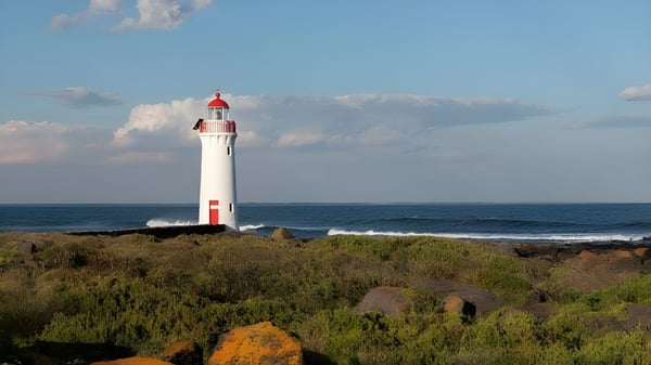 Ein weißer Leuchtturm steht an der felsigen Küste auf dem Gelände des Ashdale Secondary College.