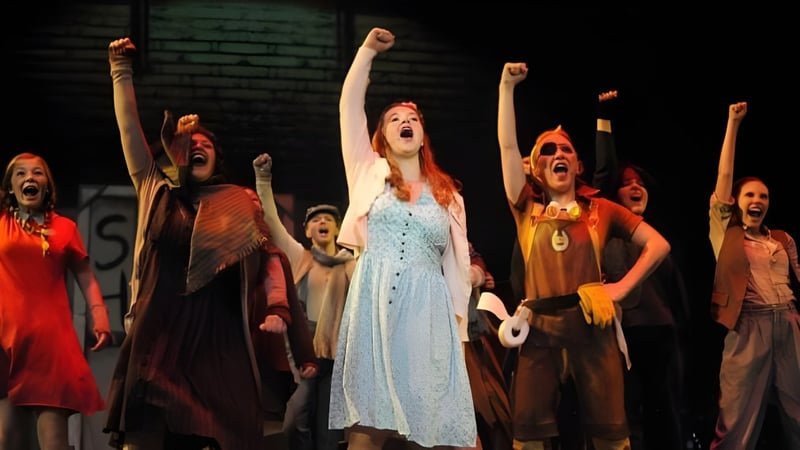 Schüler des Ashland School District führen auf einer Bühne mit abgedunkeltem Licht ein Theaterstück auf.