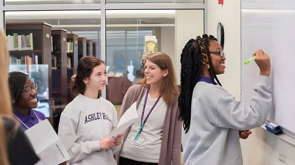 Eine Gruppe von Schülerinnen und Schülern der Ashley Hall School steht im Flur und unterhält sich miteinander.