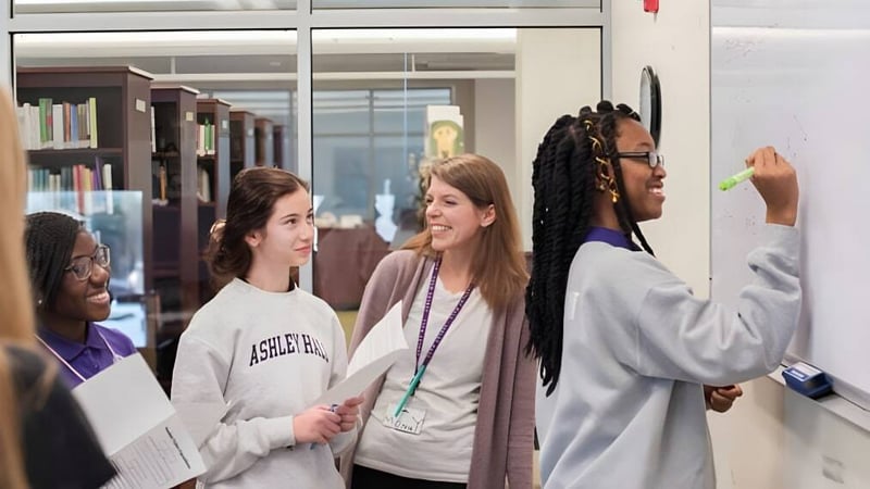 Eine Gruppe von Schülerinnen und Schülern der Ashley Hall School steht im Flur und unterhält sich miteinander.