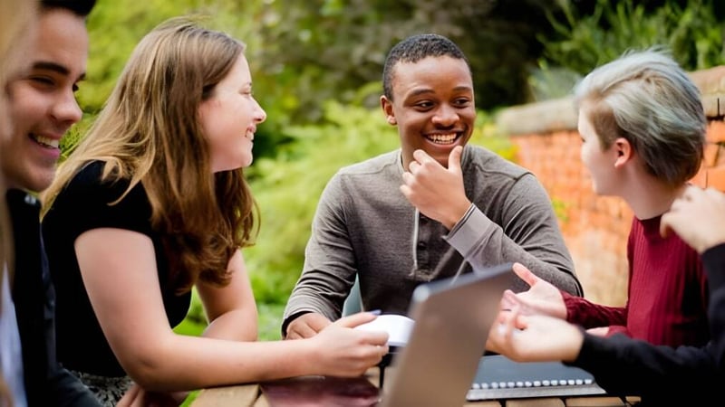 Schüler des Ashville College führen im grünen Außenbereich eine lebhafte Unterhaltung.