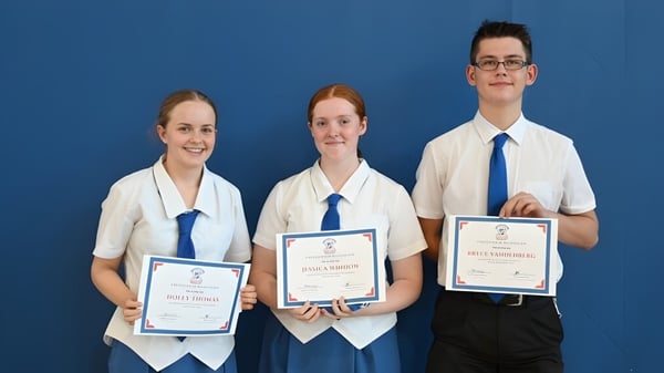 Drei Schülerinnen und Schüler der Aspley State High School halten gemeinsam ihre Zertifikate vor blauem Hintergrund.