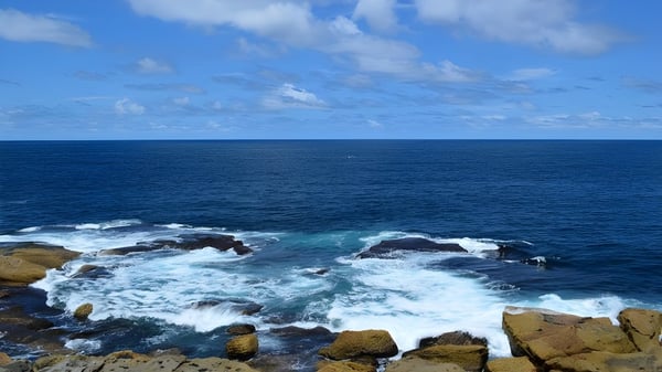 Die Küste mit felsigen Klippen und dem tiefblauen Ozean im Hintergrund, nahe der Aspley State High School.