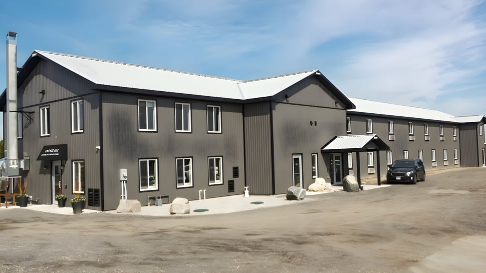 Das moderne mehrstöckige Gebäude des Athlete Institute ist von einem Kiesweg und Landschaftselementen umgeben.