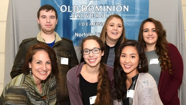 Eine Gruppe von Schülern steht lächelnd vor einem Old Dominion University Banner auf dem Campus der Atlantic Shores Christian School.
