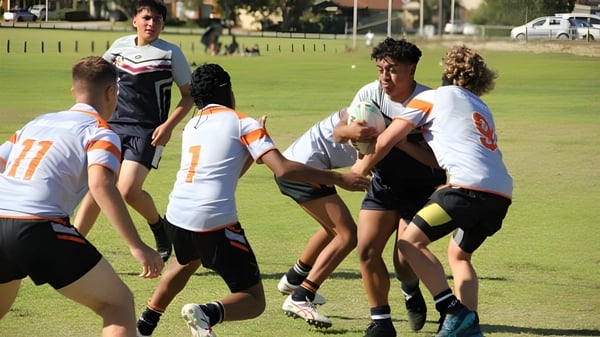 Schülerinnen und Schüler des Atwell College nehmen an einer Sportaktivität auf einem grünen Feld teil.