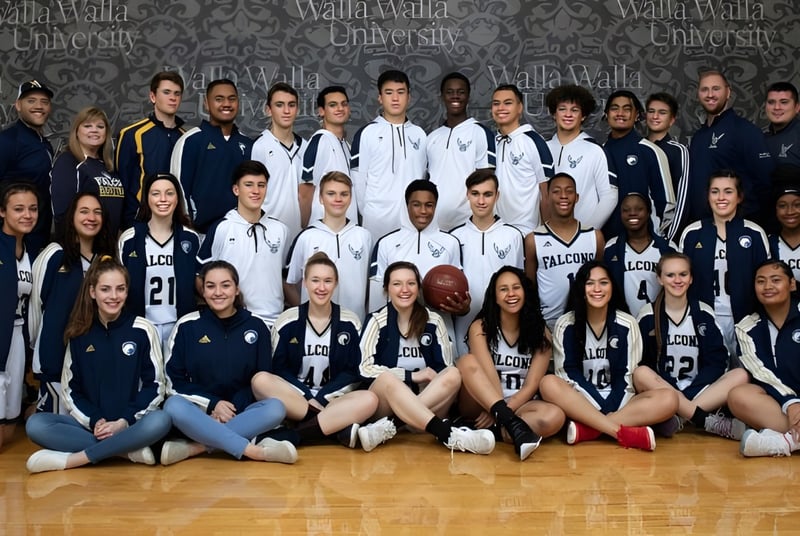 Eine Gruppe junger Athletinnen und Athleten im Sportzentrum der Auburn Adventist Academy posiert gemeinsam vor dem Logo.