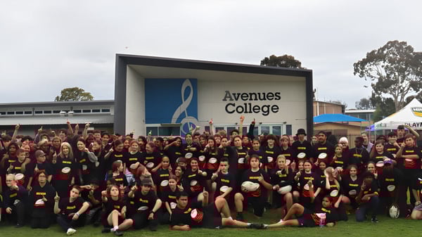 Eine große Gruppe von Schülern steht vor dem Gebäude des Avenues College.