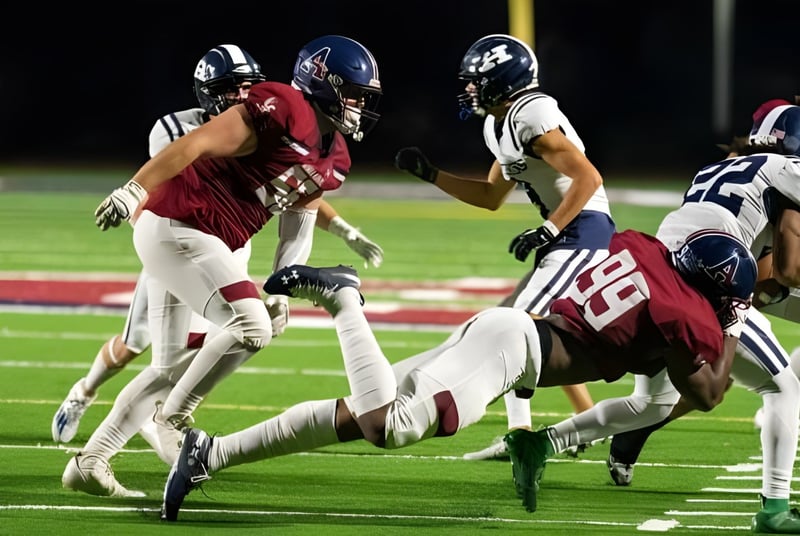 Schüler der Avon Old Farms School spielen ein Football-Spiel und führen einen Tackling auf dem Spielfeld aus.
