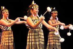 Drei Schülerinnen des Awatapu College führen einen traditionellen ethnischen Tanz auf einer Bühne auf.