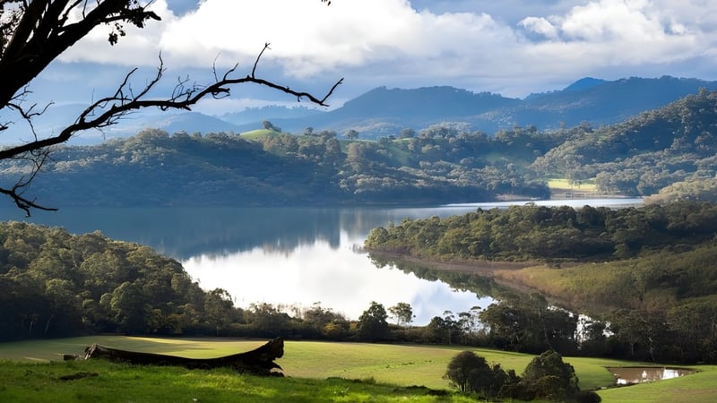 Ein ruhiger See mit grünen Hügeln und Bergen, aufgenommen in der Nähe der Balga Senior High School.