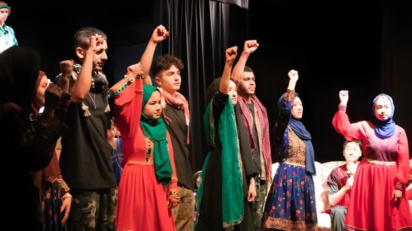 Eine Gruppe von Schülern der Balga Senior High School führt in bunter traditioneller Kleidung auf einer Bühne auf.