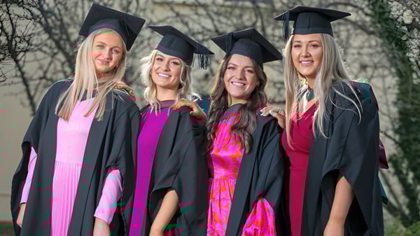 Vier Absolventinnen der Balla Secondary School stehen gemeinsam im Freien in ihren Abschlussroben.